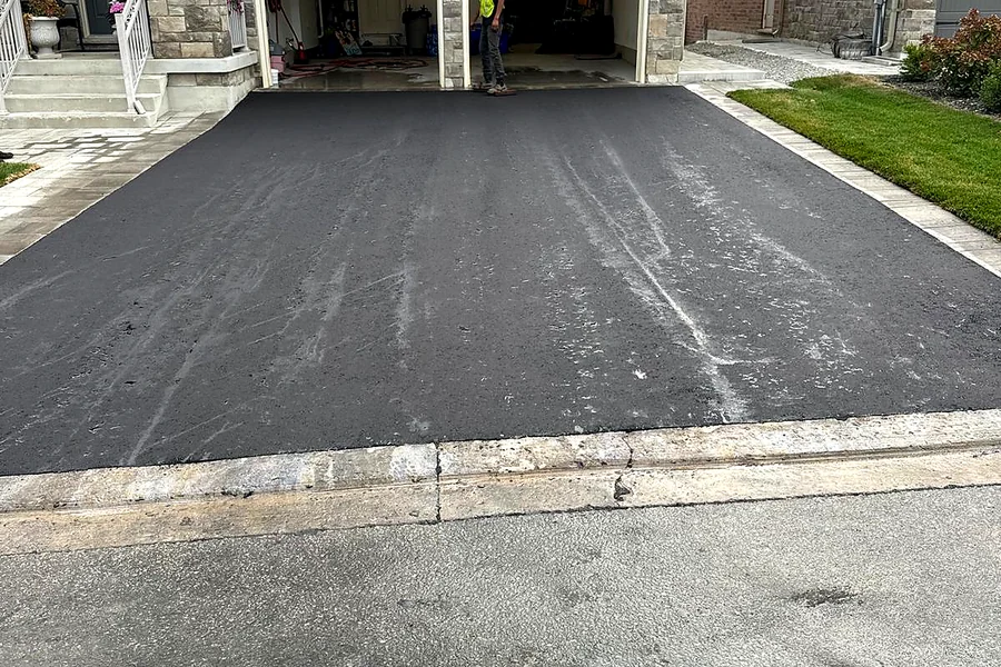 Newly paved asphalt driveway at a two-car garage