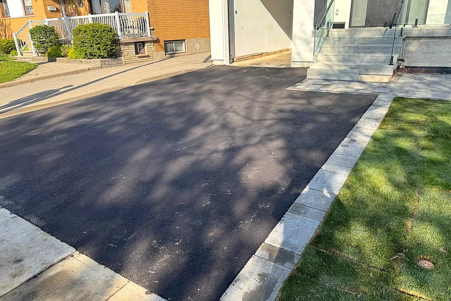 Asphalt driveway widened with a stone border