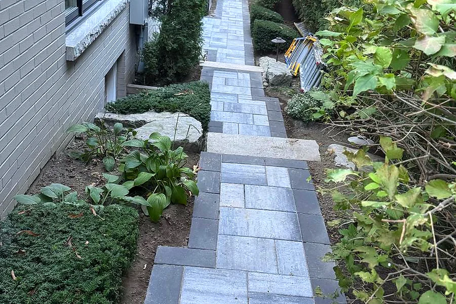 Narrow interlock walkway beside a house